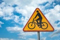 Yellow-red road sign cyclists against the sky