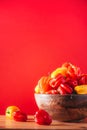 Yellow and red scotch bonnet chili peppers in wooden bowl over red background. Copy space. Royalty Free Stock Photo