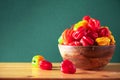 Yellow and red scotch bonnet chili peppers in wooden bowl over green background. Copy space. Royalty Free Stock Photo