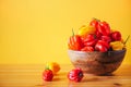 Yellow and red scotch bonnet chili peppers in wooden bowl over orange background. Copy space. Royalty Free Stock Photo