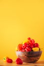 Yellow and red scotch bonnet chili peppers in wooden bowl over orange background. Copy space. Royalty Free Stock Photo