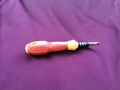 Yellow and red screwdriver isolated on violet background Royalty Free Stock Photo