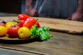 yellow and red tomatoes, lettuce and bell pepper with water drops. man in apron. Royalty Free Stock Photo