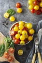 Yellow and red tomatoes in plate, isolated over dark background