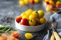 Yellow and red tomatoes in plate, isolated over dark background