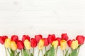 Yellow red tulips isolated on a wooden white background. lay flat, top view