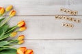 Yellow and red tulips on whitewashed wood with Mother`s Day mess Royalty Free Stock Photo