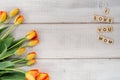 Yellow and red tulips on whitewashed wood with Mother`s Day mess Royalty Free Stock Photo