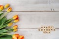 Yellow and red tulips on whitewashed wood with Mother`s Day mess Royalty Free Stock Photo