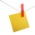 Yellow reminder note hanging on a red clothespin