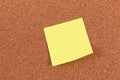 Yellow reminder sticky note on cork board Royalty Free Stock Photo