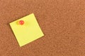 Yellow reminder sticky note on cork board Royalty Free Stock Photo