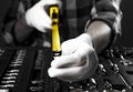 Yellow retractable tape measure tool spread to camera in male hands in white gloves over toolbox, close up Royalty Free Stock Photo