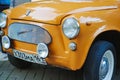 A yellow retro Zaporozhets at an exhibition of old Soviet cars.