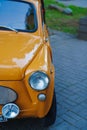 A yellow retro Zaporozhets at an exhibition of old Soviet cars.