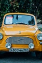 A yellow retro Zaporozhets at an exhibition of old Soviet cars.