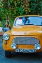 A yellow retro Zaporozhets at an exhibition of old Soviet cars.