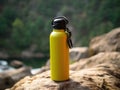 Yellow reusable steel thermo water bottle on the background of the waterfall. Generative AI