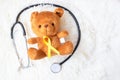 Yellow Ribbon on Bear doll with stethoscope on white background for supporting kid living and illness. September Childhood Cancer Royalty Free Stock Photo