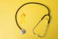 Yellow Ribbon and Stethoscope on yellow background for supporting people living and illness. July Sarcoma cancer, Suicide Royalty Free Stock Photo