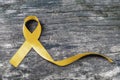 Yellow ribbon symbolic color for Sarcoma Bone cancer awareness and suicide prevention on aged wood isolated with clipping path