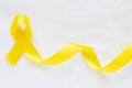 Yellow ribbon on white isolated background, copy space. Bone cancer, Sarcoma Awareness, childhood cancer awareness, Royalty Free Stock Photo