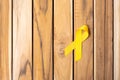 Yellow Ribbon on wooden table background for supporting people living and illness. September Suicide prevention day, Childhood Royalty Free Stock Photo