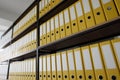 Yellow ring binders with files put in long rows on shelves Royalty Free Stock Photo