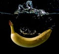 Yellow Banana splashing in water on black