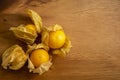 Yellow ripe Cape gooseberry fruit in a brown wooden background know as goldenberry or physalis, top view image Royalty Free Stock Photo