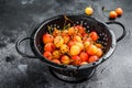 Yellow ripe cherries in a colander. Black background. Top view Royalty Free Stock Photo