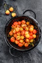 Yellow ripe cherries in a colander. Black background. Top view Royalty Free Stock Photo