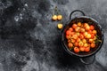 Yellow ripe cherries in a colander. Black background. Top view. Copy space Royalty Free Stock Photo