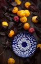 Yellow ripe plums and empty ceramic plate among leaves on rustic old wooden table background Royalty Free Stock Photo