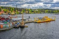 Yellow ro-ro ferry, sail ships and steam boats moored at piers of Beckholms ship yard in Stockholm. High point general view.