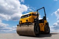 Yellow road roller machine on a background of blue sky Royalty Free Stock Photo