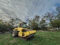 Yellow Road roller, small model, on display in a meadow. A road roller, or compactor, is used for asphalt and road renovation and Royalty Free Stock Photo