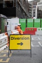 Yellow Road Sign with Arrow, Diversion: Barrier and Workers in background Royalty Free Stock Photo
