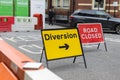 Yellow Road Sign with Arrow: Diversion Text and Barrier Royalty Free Stock Photo