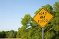 Road May Flood Sign In Summer With Green Trees and Blue Sky