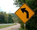 Yellow road sign indicating left turn Royalty Free Stock Photo