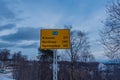 Yellow road sign with leafless trees in the background. Norway.