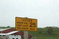 Yellow caution road sign in front of a landscape with a barn Royalty Free Stock Photo