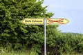 Yellow road signs pointing in opposite directions with German text Bleib Zuhause meaning Stay Home,  and Coronavirus, rural Royalty Free Stock Photo