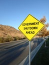 Yellow roadside warning sign reading government shutdown ahead warning Royalty Free Stock Photo