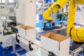 Yellow robotic arm manipulator working with cardboard boxes - sorting system Royalty Free Stock Photo