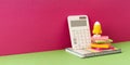 Yellow rocket stands on desk and pink background with calculator Royalty Free Stock Photo