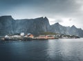 Yellow rorbu houses of Sakrisoy fishing village on a cloudy day with mountains in the background. Lofoten islands Royalty Free Stock Photo