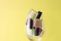 Yellow, rose nail polish bottles set. Nail polish bottles in wine glass. Yellow nail polsih bottles on yellow background Royalty Free Stock Photo