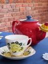 Yellow rose tea cup with red teapot Royalty Free Stock Photo